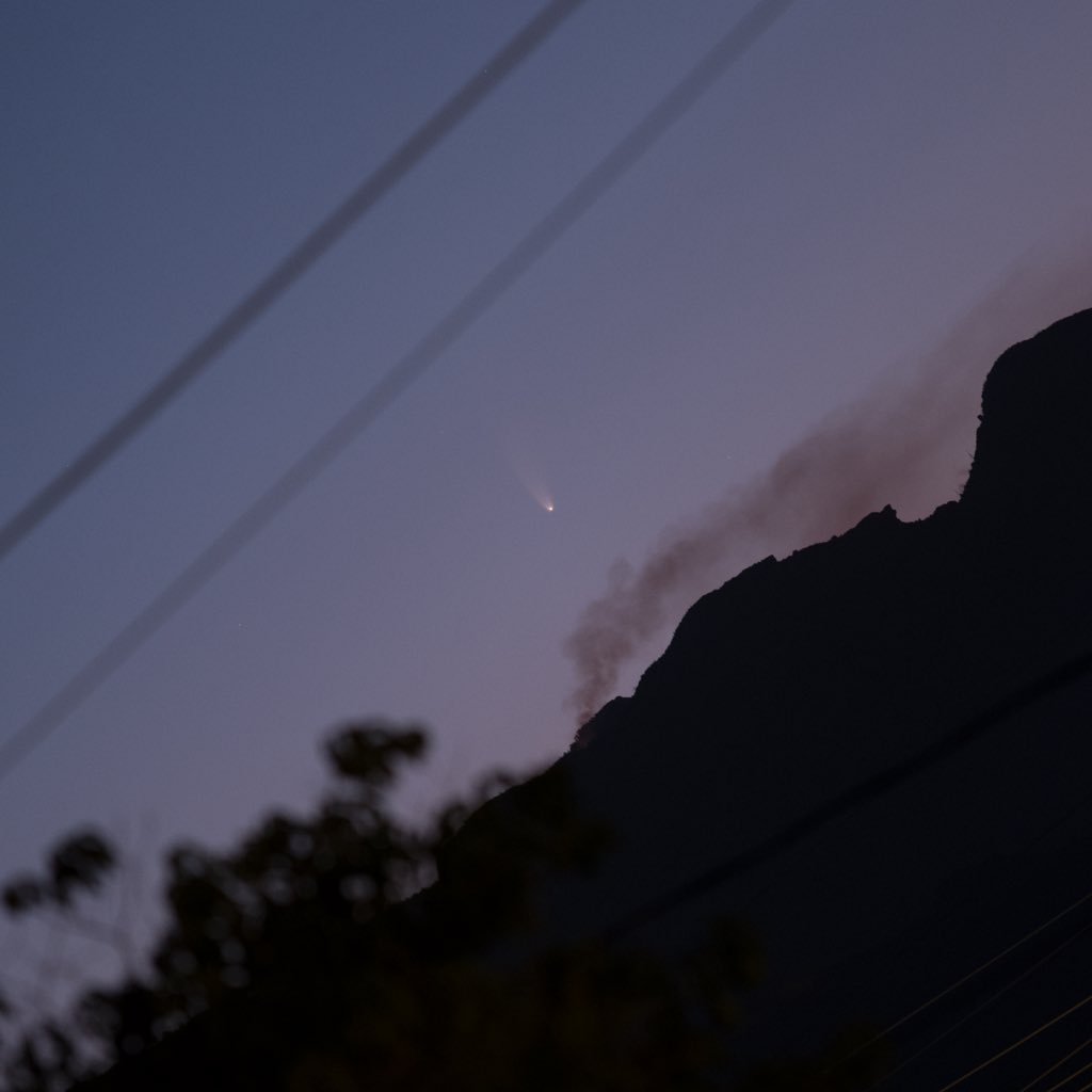 photo of comet over mountain ridge line and smoke